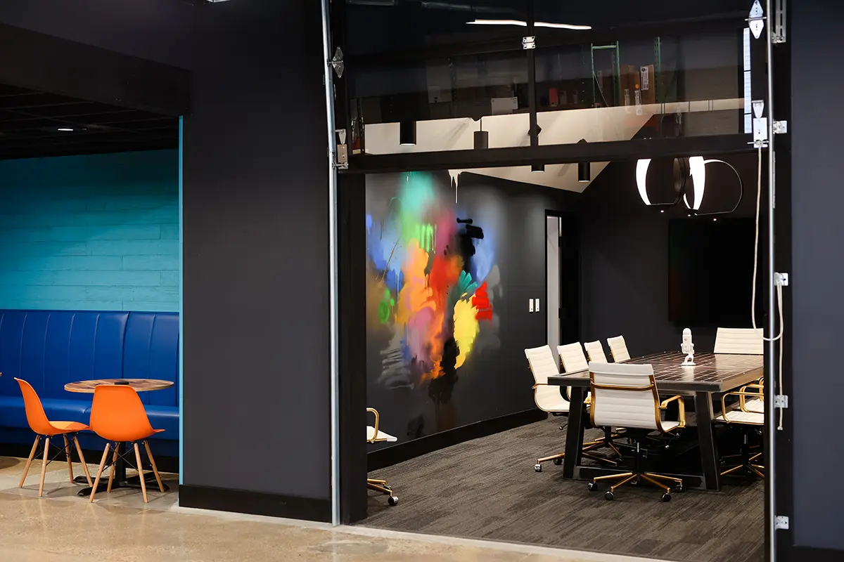 Modern conference room in Greenwood Indiana with glass walls, large meeting table, and colorful feature wall