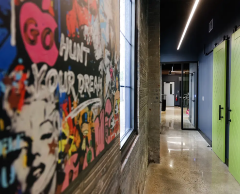 Creative office corridor in Greenwood Indiana with graffiti wall, glass doors, and polished concrete floors