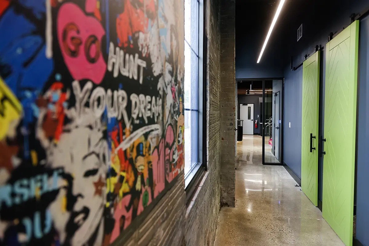 Creative office corridor in Greenwood Indiana with graffiti wall, glass doors, and polished concrete floors