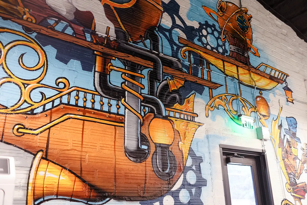 Colorful mural feature wall in Greenwood Indiana office with industrial details and creative workplace design