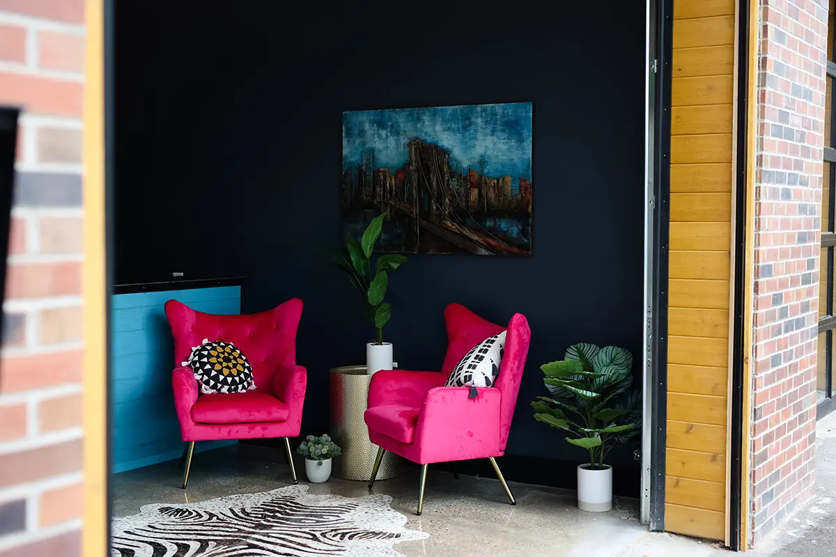 Office lounge in Greenwood Indiana with bold pink chairs, modern artwork, and relaxed seating area