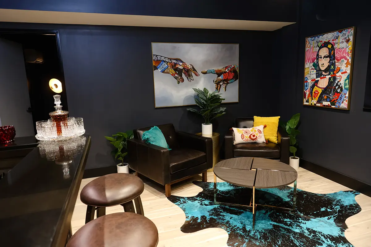 Moody office lounge in Greenwood Indiana with dark walls, leather seating, and artistic wall décor