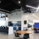 Modern office café and breakroom in Fishers Indiana with bar seating, pendant lighting, and open collaboration area