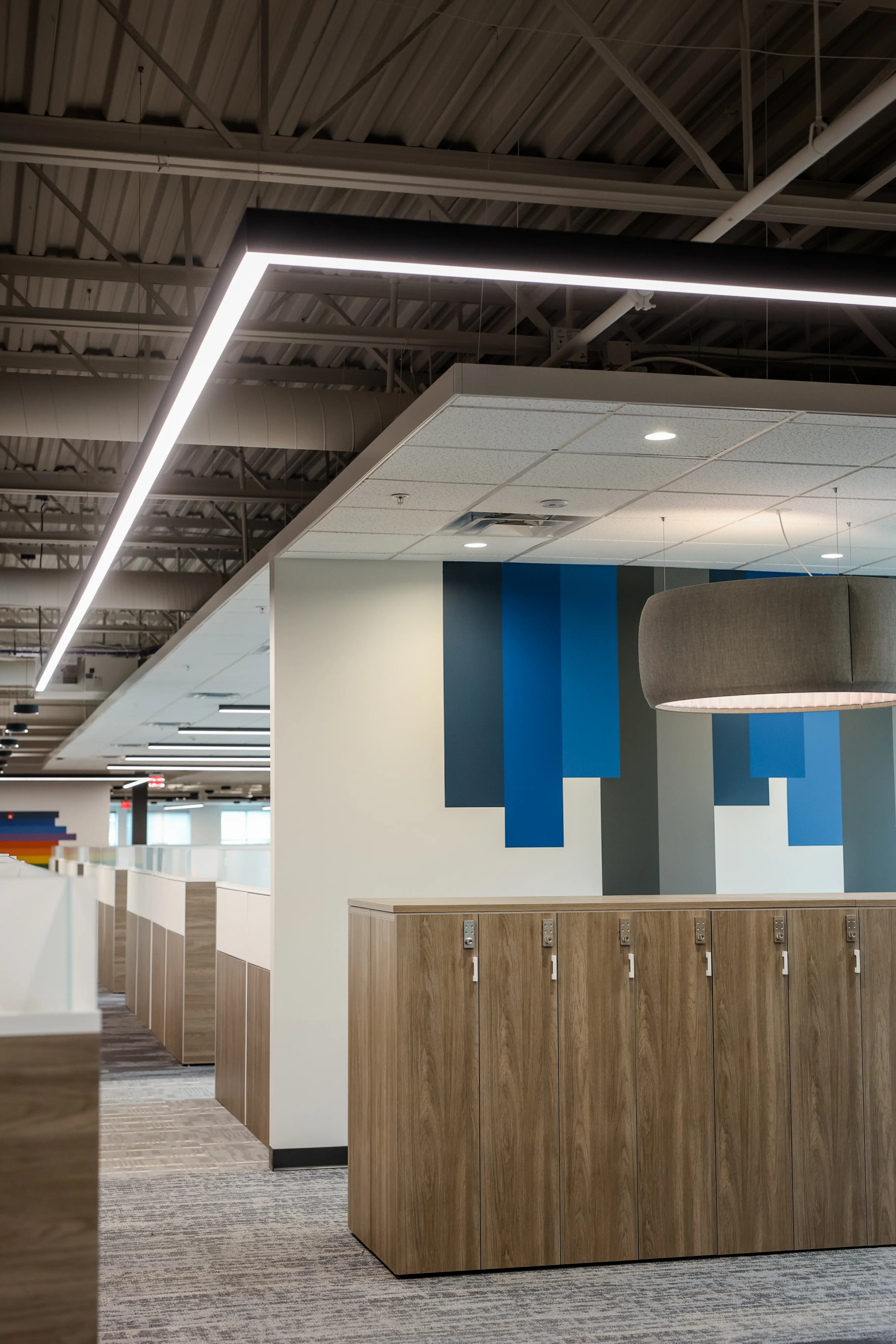 Open office workstation area in Zionsville, Indiana with custom lockers, modern lighting, and collaborative workspace design