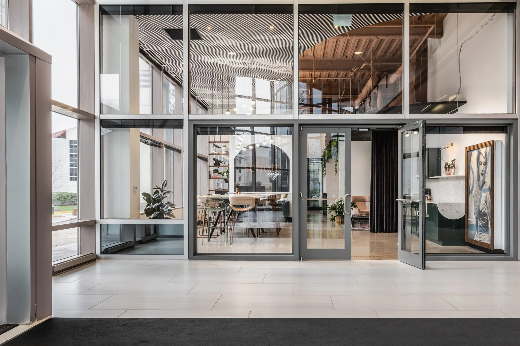 Modern office entry in Indianapolis, Indiana with glass storefront, natural light, and collaborative workspace beyond