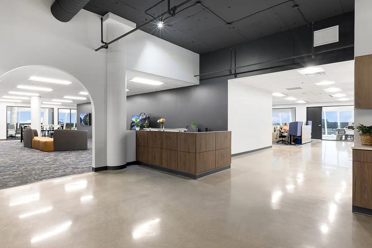 Open office lobby with modern lighting, lounge seating, and polished concrete floors in Indianapolis