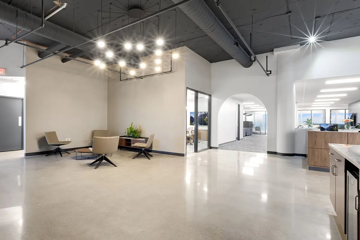 Office reception area transitioning into open workspace with lounge seating and workstations in Indianapolis