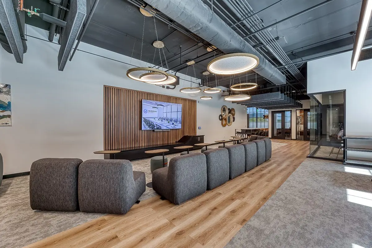 Open office lounge design in northern Indiana with soft seating, wood accents, and modern lighting fixtures