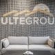 Office lobby seating area with PulteGroup branding wall and modern sofa in Carmel, Indiana workplace design