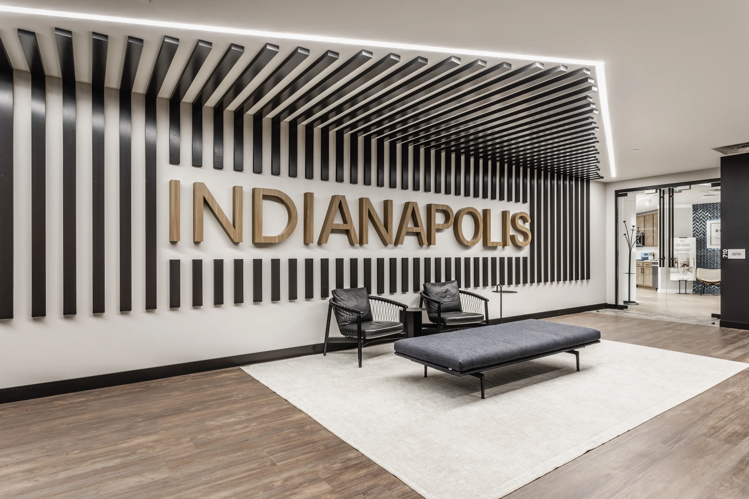 Office lobby with Indianapolis feature wall and modern seating area in Pulte Carmel workplace design
