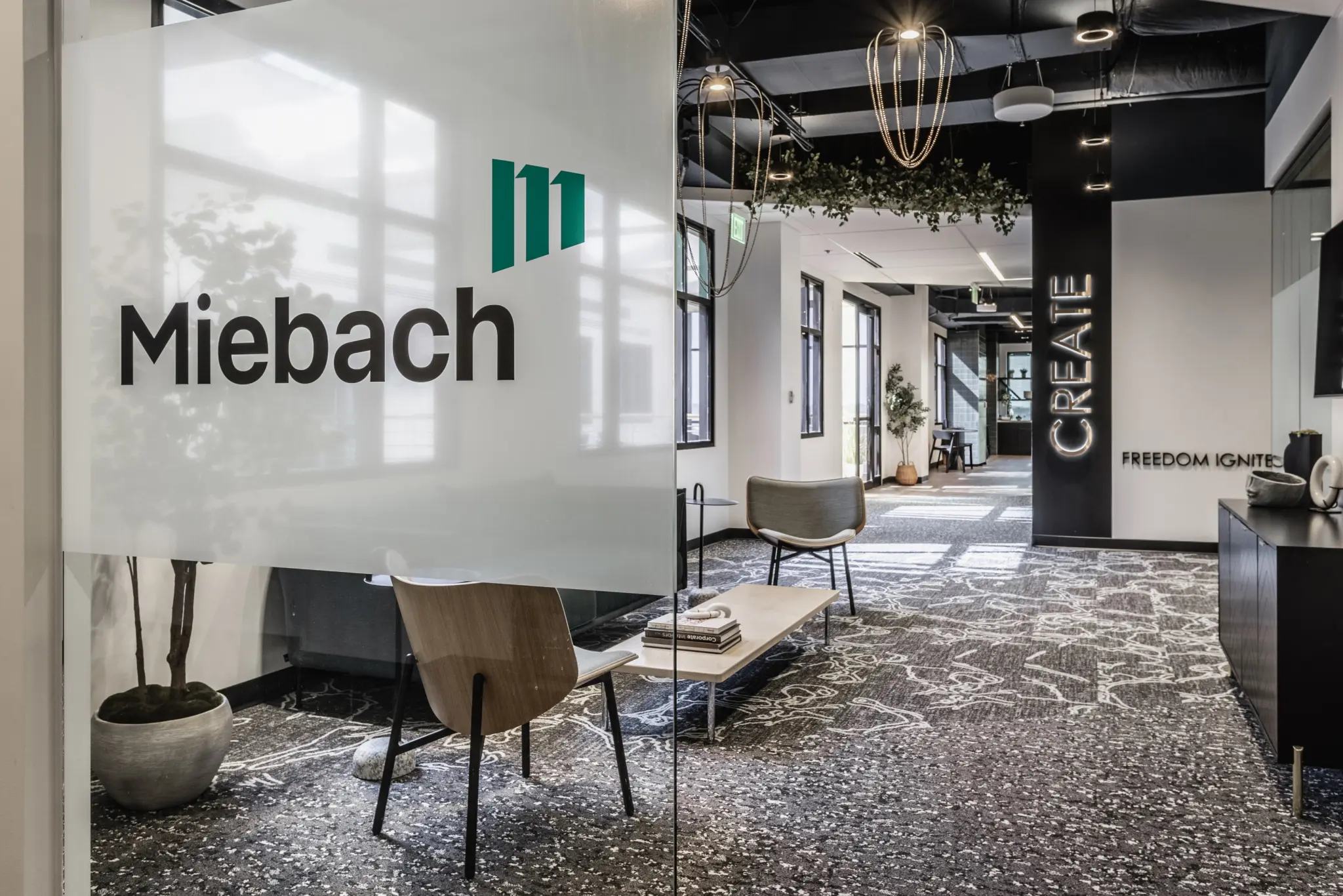 Corporate office reception design in Fishers, Indiana with branded glass wall, lounge seating, and modern finishes