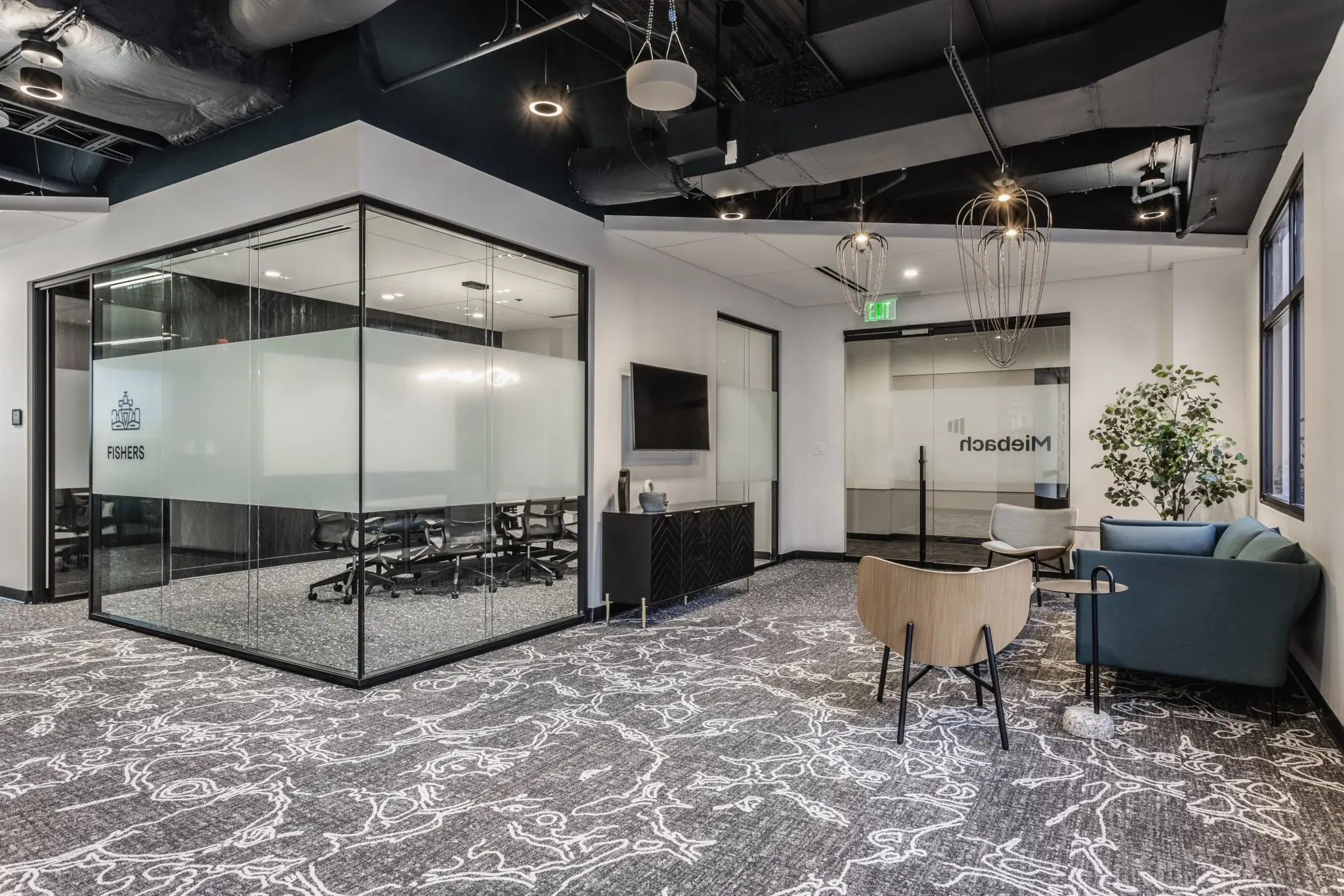 Open office in Fishers, Indiana with glass conference room, lounge seating, and modern lighting