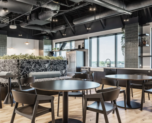 Office café in Fishers, Indiana with dining tables, booth seating, and open kitchen layout
