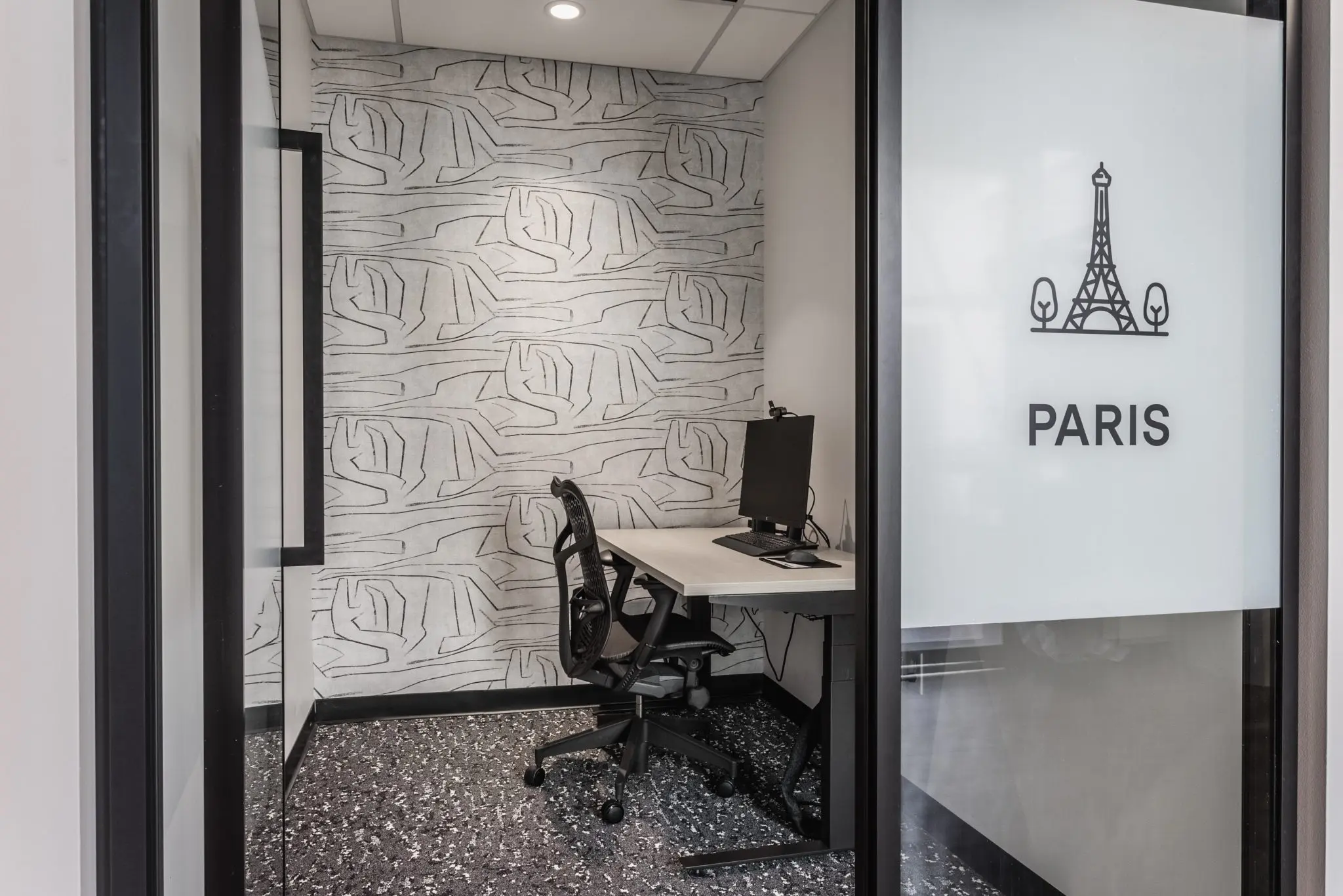 Private office phone booth in northern Indiana with workstation, acoustic finishes, and glass door
