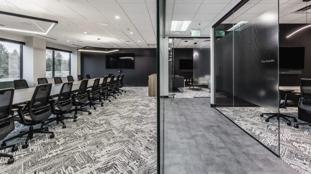 Large training room in Indianapolis, Indiana with conference tables, rolling chairs, and presentation screen