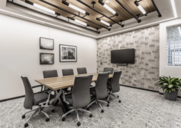 Small conference room in Indianapolis, Indiana with meeting table, wall-mounted screen, and contemporary lighting