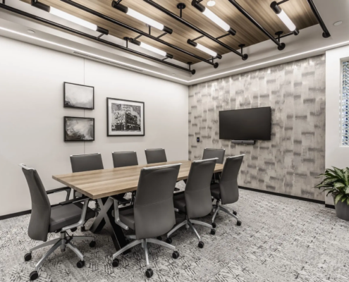 Small conference room in Indianapolis, Indiana with meeting table, wall-mounted screen, and contemporary lighting