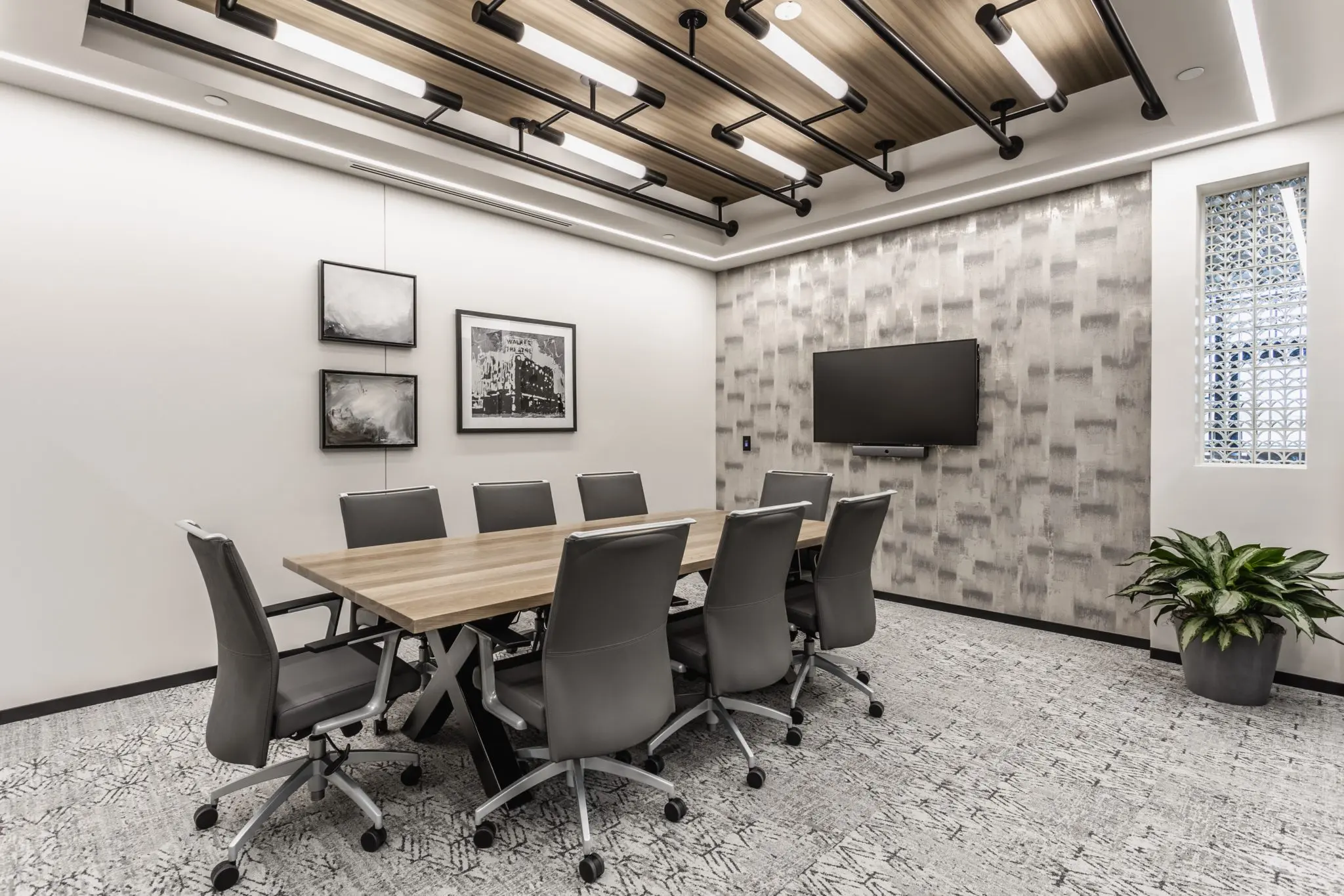 Small conference room in Indianapolis, Indiana with meeting table, wall-mounted screen, and contemporary lighting