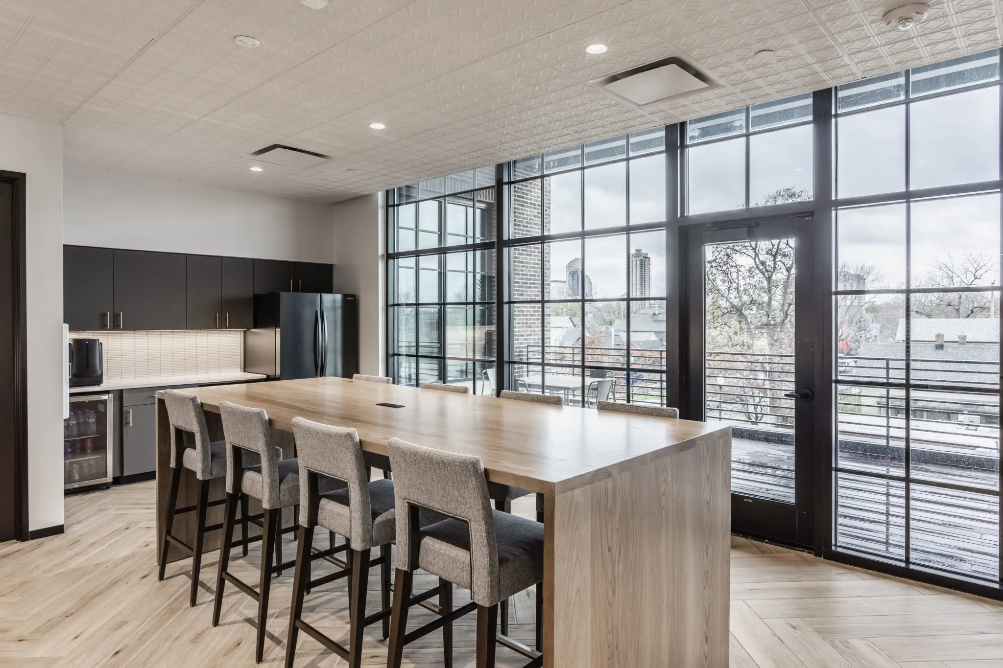 Office kitchen in Indianapolis with large island, tile backsplash, and modern cabinetry