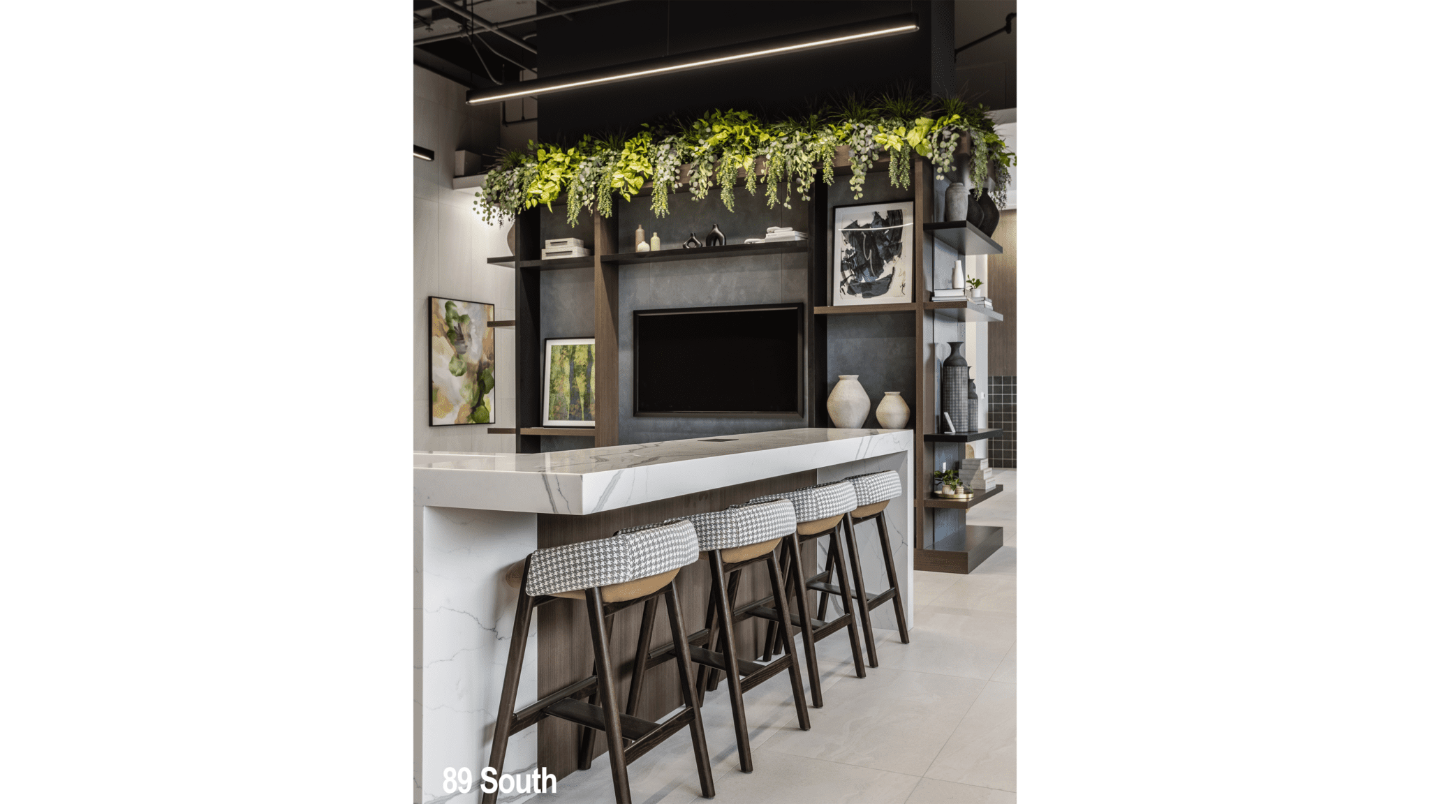 Commercial office lobby design in Indianapolis with bar seating, greenery ceiling feature, and modern shelving