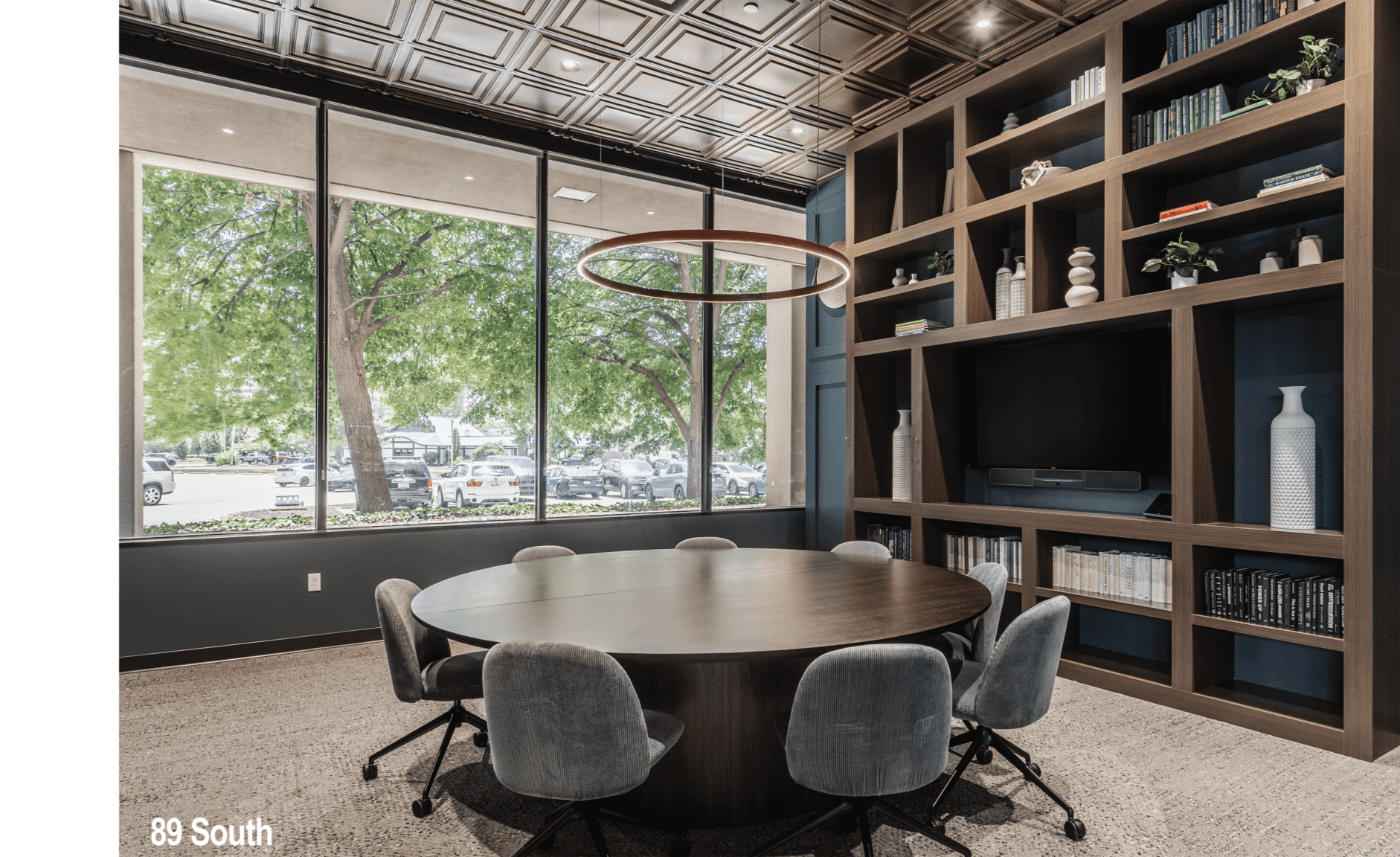 Small conference room in Indianapolis with meeting table, wall-mounted screen, and contemporary lighting