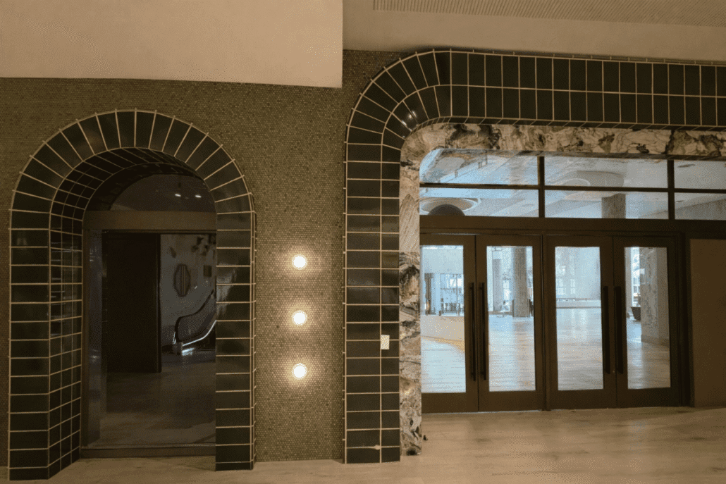 Architectural tile archway detail in a modern interior with layered materials and lighting