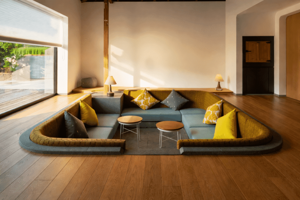 Modern conversation pit seating area with warm wood flooring and residential-inspired design