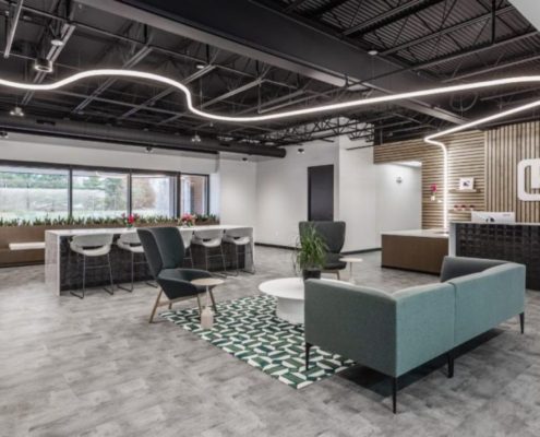 Modern office reception area with collaborative seating, open workspace, and contemporary finishes