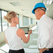 Team reviewing office renovation plans during a construction walkthrough in a commercial space