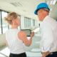 Team reviewing office renovation plans during a construction walkthrough in a commercial space