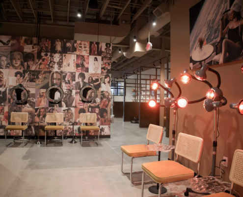 Salon interior in Fishers, Indiana with styling stations, waiting area, and feature collage wall