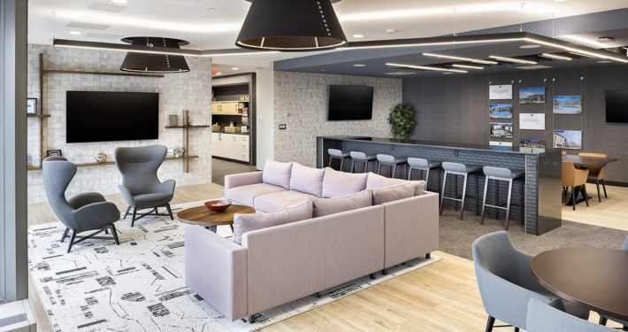 Modern office lounge at Thompson Thrift in Indianapolis featuring collaborative seating, soft finishes, and flexible workspace design.