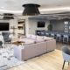Modern office lounge at Thompson Thrift in Indianapolis featuring collaborative seating, soft finishes, and flexible workspace design.